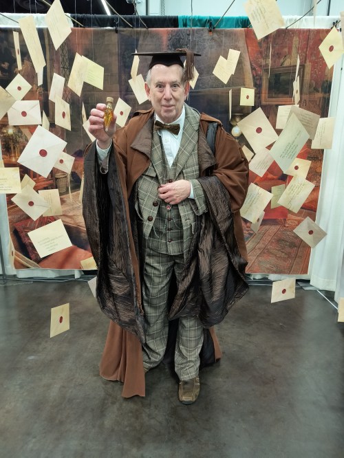 Professor Slughorn cosplayer holding up a bottle of Felix Felicis